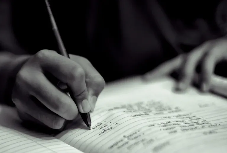 cropped-hand-person-writing-book-darkroom_result-768x517.webp